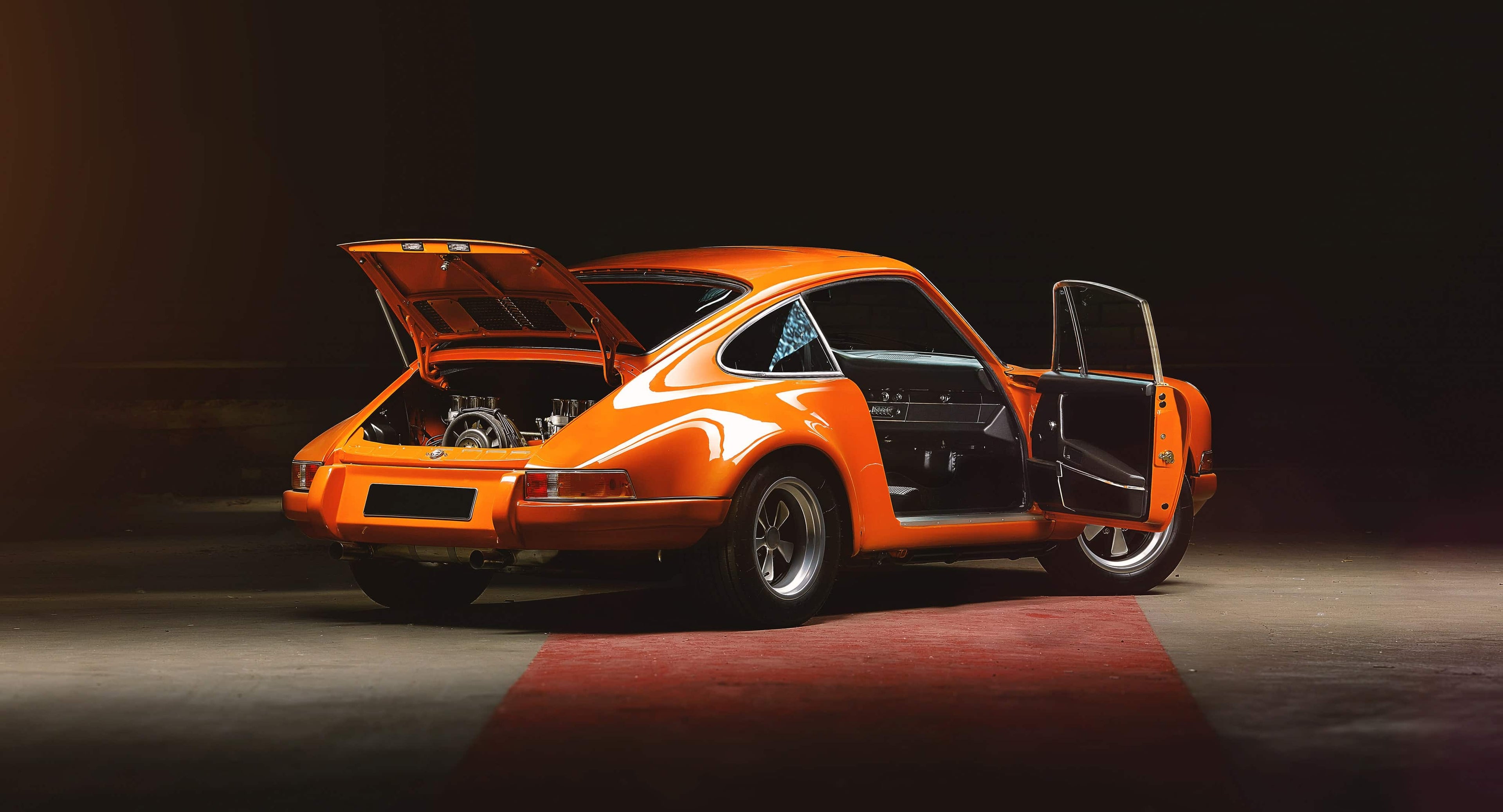 Classic orange Porsche with engine exposed